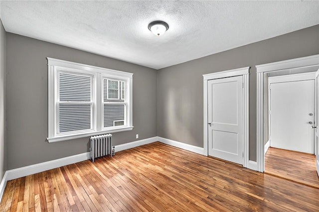 15 Melissa St, Providence, RI 02909 - unfurnished bedroom with radiator, wood-type flooring, and a textured ceiling