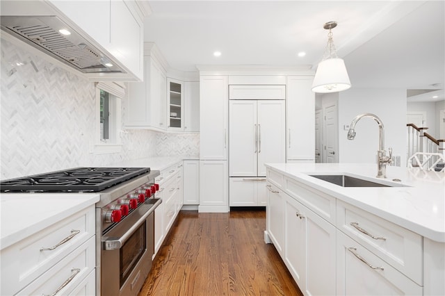 10 Linden Gate Ln, Newport, RI 02840 - kitchen featuring high quality appliances, wall chimney exhaust hood, dark wood-style flooring, white cabinetry, and hanging light fixtures