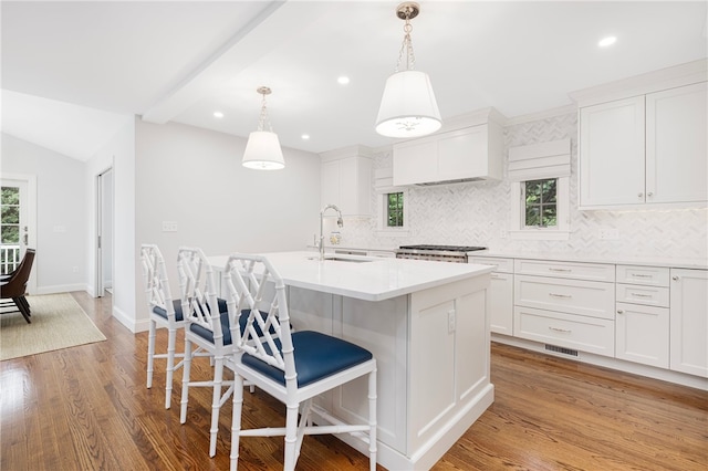 10 Linden Gate Ln, Newport, RI 02840 - kitchen with tasteful backsplash, an island with sink, white cabinets, a kitchen bar, and recessed lighting