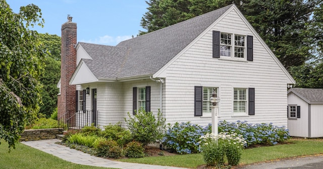 10 Linden Gate Ln, Newport, RI 02840 - view of property exterior with a chimney, a shingled roof, and an outdoor structure