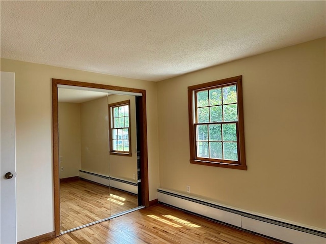 55 Circle Dr, Mansfield, CT 06250 - spare room with baseboard heating, light wood-type flooring, and a textured ceiling