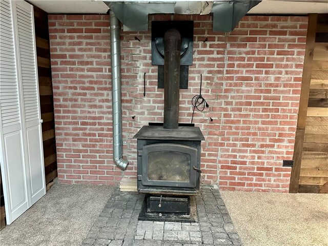 55 Circle Dr, Mansfield, CT 06250 - detailed view of a wood stove, brick wall, and carpet flooring