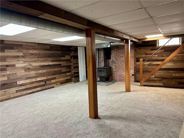 55 Circle Dr, Mansfield, CT 06250 - below grade area featuring a drop ceiling, carpet, a wood stove, wood walls, and stairway