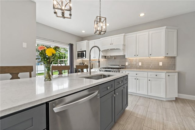 54 Michael Dr, Bristol, RI 02809 - kitchen with stainless steel appliances, a chandelier, gray cabinetry, hanging light fixtures, and tasteful backsplash