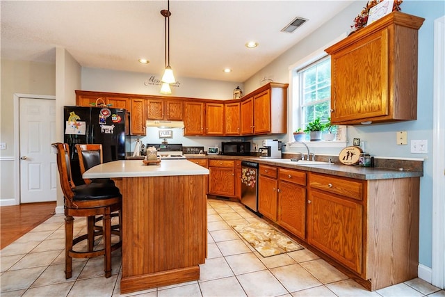 50 S Pond Dr, Coventry, RI 02816 - kitchen with black appliances, under cabinet range hood, a center island, brown cabinetry, and recessed lighting