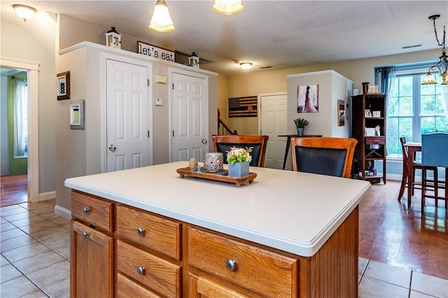 50 S Pond Dr, Coventry, RI 02816 - kitchen with light tile patterned floors, brown cabinets, a kitchen island, and light countertops