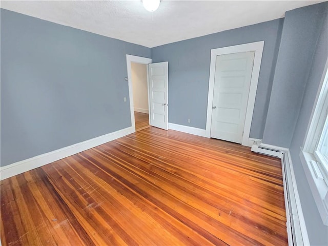 156 Broad St, Burrillville, RI 02859 - unfurnished bedroom with wood-type flooring and baseboard heating