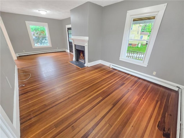 156 Broad St, Burrillville, RI 02859 - unfurnished living room featuring baseboard heating, wood finished floors, and a fireplace with flush hearth