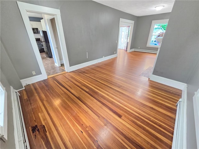 156 Broad St, Burrillville, RI 02859 - empty room with light wood-type flooring and a baseboard radiator