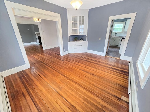 156 Broad St, Burrillville, RI 02859 - spare room featuring wood finished floors, a chandelier, and a baseboard heating unit