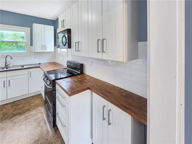 156 Broad St, Burrillville, RI 02859 - kitchen with range with electric cooktop, butcher block counters, tasteful backsplash, and white cabinetry