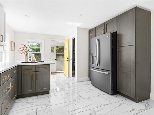 155 Hillside Ave, Providence, RI 02906 - kitchen featuring stainless steel fridge with ice dispenser, light marble finish floors, light countertops, and a peninsula
