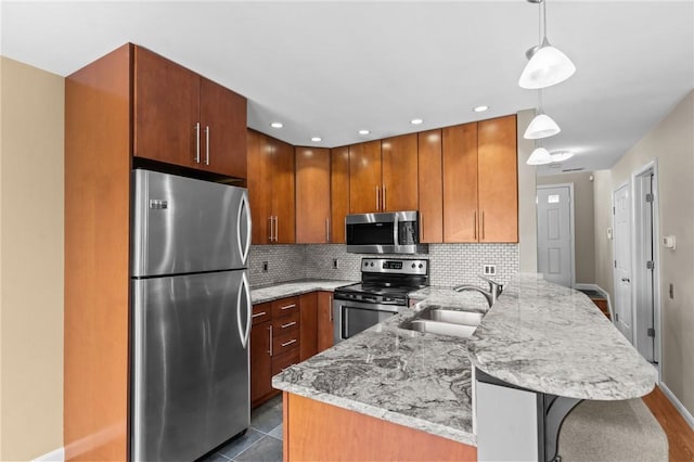 76 Valley Green Ct Unit B, North Providence, RI 02904 - kitchen featuring stainless steel appliances, a peninsula, light stone counters, decorative backsplash, and a kitchen breakfast bar