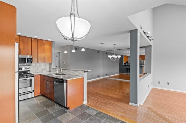 76 Valley Green Ct Unit B, North Providence, RI 02904 - kitchen featuring appliances with stainless steel finishes, a peninsula, a chandelier, brown cabinetry, and tasteful backsplash
