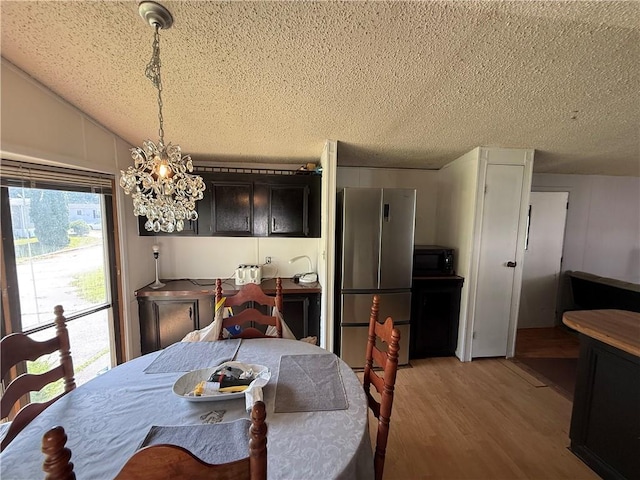 225 Brayton Ave, Tiverton, RI 02878 - dining area featuring a textured ceiling, light wood finished floors, a chandelier, and vaulted ceiling