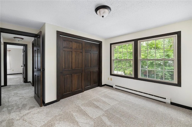 50 Betony Rd, Narragansett, RI 02874 - unfurnished bedroom featuring a baseboard radiator, light carpet, a closet, and a textured ceiling