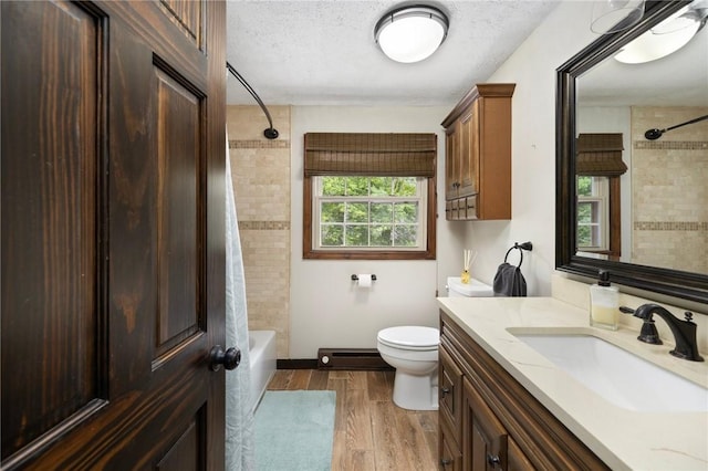 50 Betony Rd, Narragansett, RI 02874 - bathroom featuring vanity, wood finished floors, tub / shower combination, a baseboard radiator, and a textured ceiling