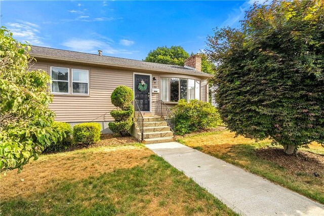 59 Columbus Ave, North Providence, RI 02911 - bungalow-style house featuring a chimney and a front lawn