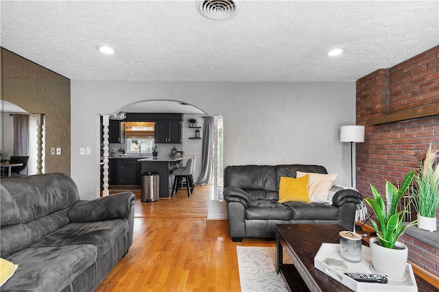 59 Columbus Ave, North Providence, RI 02911 - living area featuring arched walkways, light wood-style flooring, and a textured ceiling