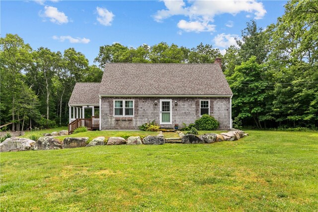 140 Long Hwy, Little Compton, RI 02837 - view of front facade featuring a chimney, a front yard, a shingled roof, and a wooden deck