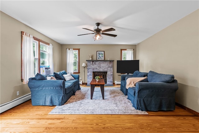 140 Long Hwy, Little Compton, RI 02837 - living room with a ceiling fan, baseboard heating, wood finished floors, a fireplace, and a baseboard heating unit