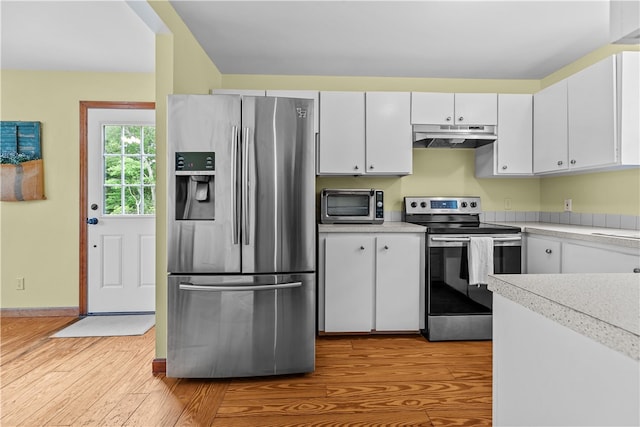 140 Long Hwy, Little Compton, RI 02837 - kitchen with stainless steel appliances, under cabinet range hood, light wood-style flooring, light countertops, and white cabinets