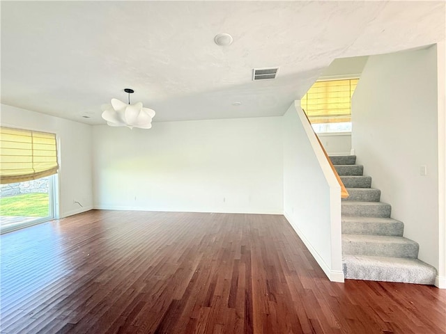 77 Batcheller Ave, Cranston, RI 02920 - unfurnished living room with wood finished floors, stairway, and a chandelier
