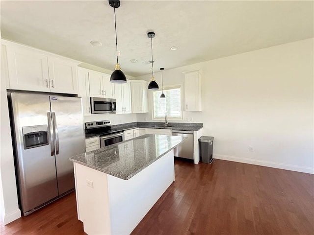 77 Batcheller Ave, Cranston, RI 02920 - kitchen with appliances with stainless steel finishes, white cabinets, dark wood-style flooring, a center island, and dark stone countertops