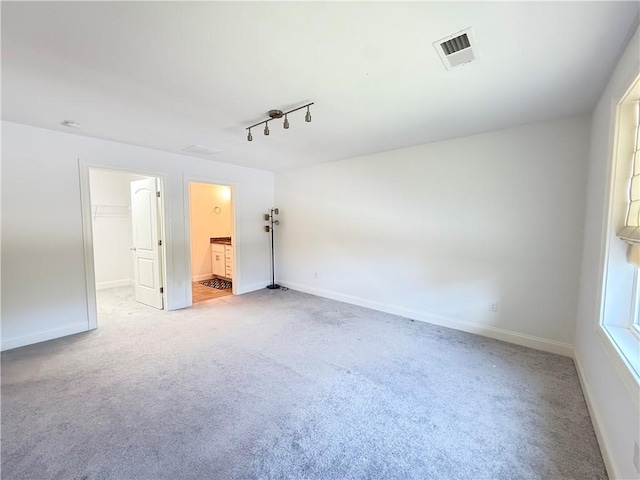 77 Batcheller Ave, Cranston, RI 02920 - unfurnished bedroom with a walk in closet, light colored carpet, rail lighting, and ensuite bathroom