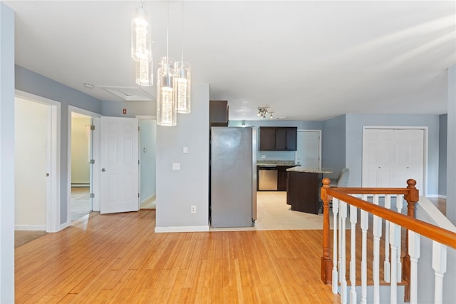 22 Riverdale Rd, Westerly, RI 02891 - kitchen with stainless steel appliances, dark brown cabinetry, light wood-type flooring, hanging light fixtures, and a baseboard heating unit