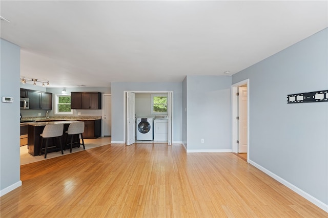 22 Riverdale Rd, Westerly, RI 02891 - unfurnished living room featuring washing machine and clothes dryer, light wood finished floors, and healthy amount of natural light