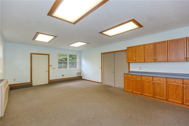 422 Buxton St, North Smithfield, RI 02896 - kitchen with brown cabinetry, light carpet, open floor plan, and dark countertops