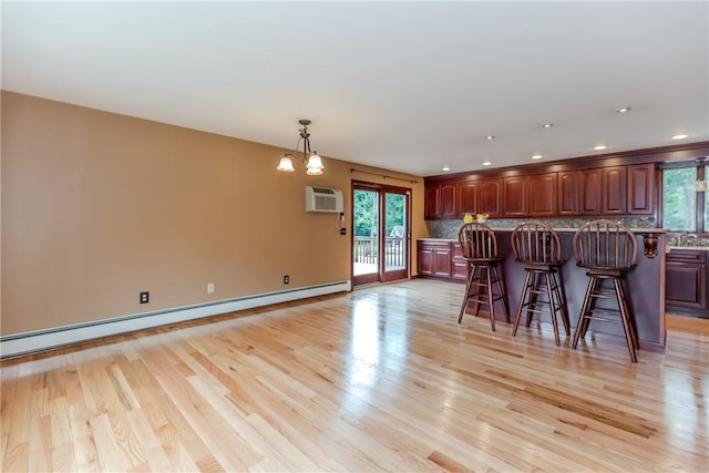 422 Buxton St, North Smithfield, RI 02896 - kitchen with a breakfast bar area, a baseboard heating unit, decorative backsplash, light wood-style flooring, and recessed lighting