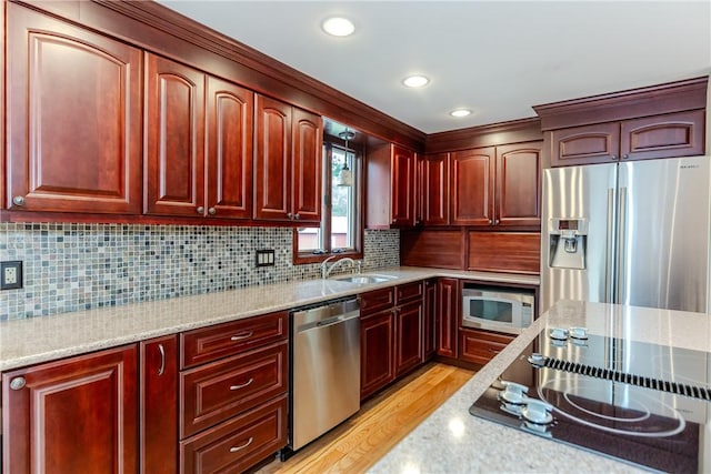 422 Buxton St, North Smithfield, RI 02896 - kitchen featuring appliances with stainless steel finishes, reddish brown cabinets, light stone counters, backsplash, and light wood-style floors