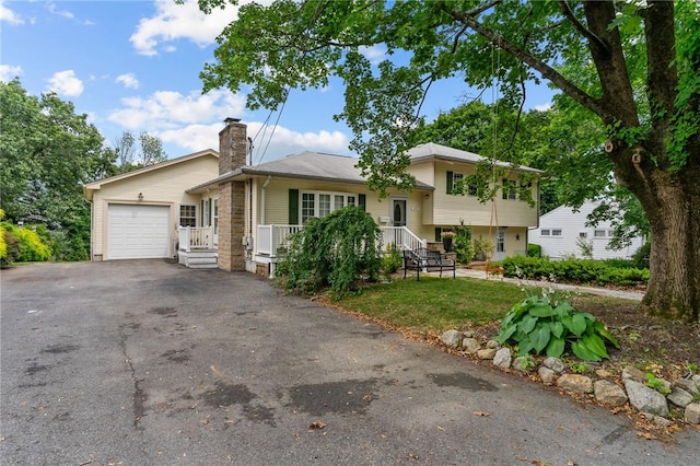 203 Pulaski St, West Warwick, RI 02893 - split level home with a chimney, a garage, and driveway