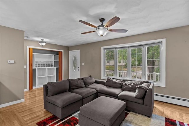 203 Pulaski St, West Warwick, RI 02893 - living room featuring a baseboard heating unit, a ceiling fan, and light wood-style flooring