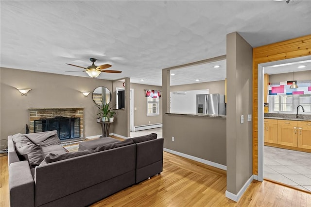 203 Pulaski St, West Warwick, RI 02893 - living area featuring a baseboard heating unit, light wood-style floors, a fireplace, ceiling fan, and recessed lighting