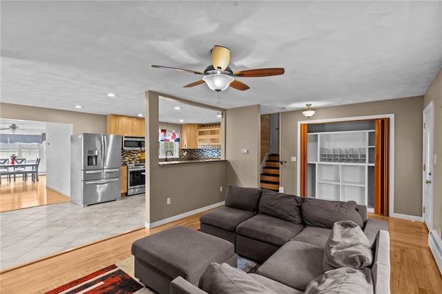 203 Pulaski St, West Warwick, RI 02893 - living room featuring a ceiling fan, recessed lighting, a baseboard radiator, light wood-style floors, and stairs