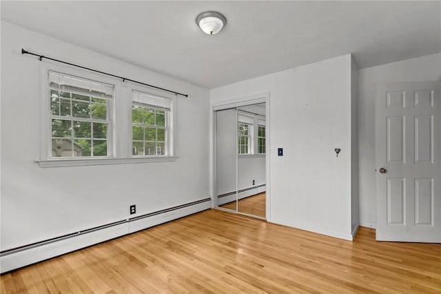 203 Pulaski St, West Warwick, RI 02893 - unfurnished bedroom featuring light wood finished floors, multiple windows, and baseboard heating