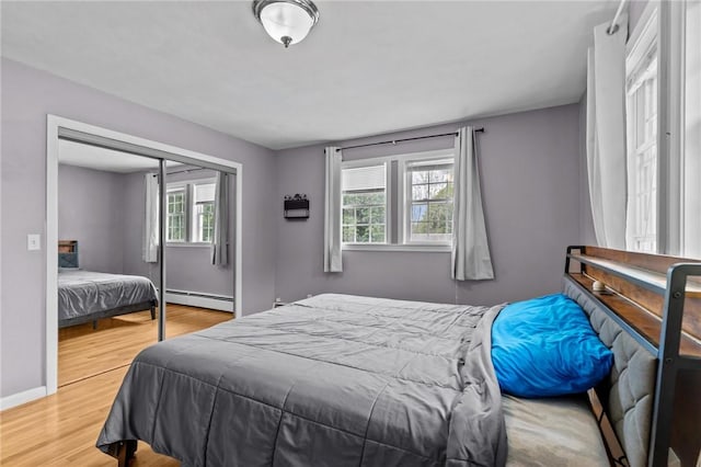 203 Pulaski St, West Warwick, RI 02893 - bedroom with a baseboard radiator, multiple windows, light wood-style flooring, and a closet