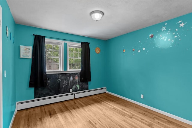 203 Pulaski St, West Warwick, RI 02893 - unfurnished room featuring a baseboard heating unit and wood finished floors