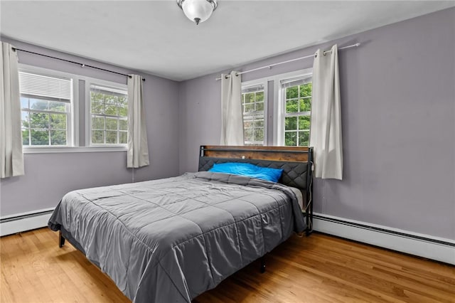 203 Pulaski St, West Warwick, RI 02893 - bedroom with multiple windows, wood finished floors, and a baseboard heating unit