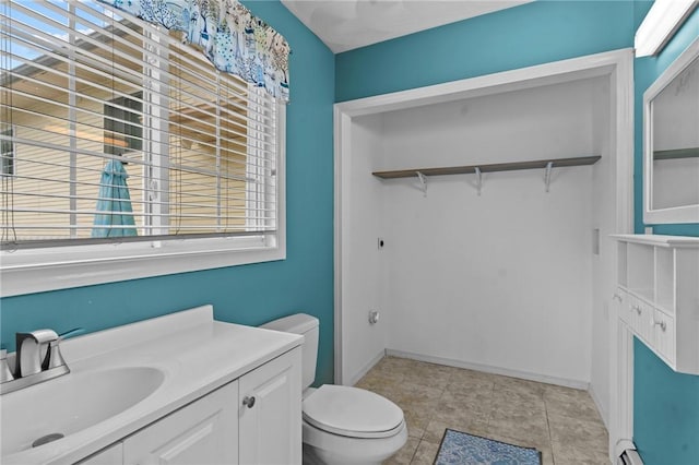203 Pulaski St, West Warwick, RI 02893 - bathroom with vanity, healthy amount of natural light, a walk in closet, and a baseboard radiator