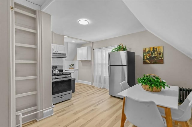 1413 Broad St, Providence, RI 02905 - kitchen with stainless steel appliances, under cabinet range hood, white cabinets, light wood-type flooring, and light countertops