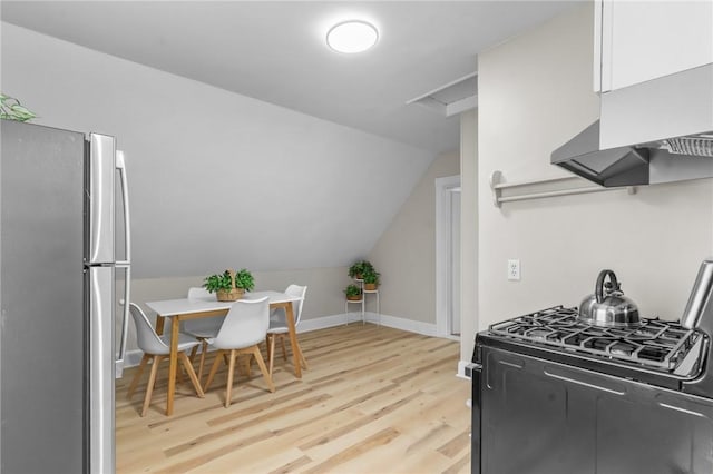 1413 Broad St, Providence, RI 02905 - kitchen featuring freestanding refrigerator, gas stove, light wood-style floors, lofted ceiling, and white cabinets