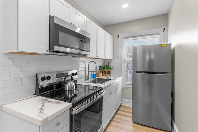 1413 Broad St, Providence, RI 02905 - kitchen with stainless steel appliances, white cabinets, light countertops, and tasteful backsplash