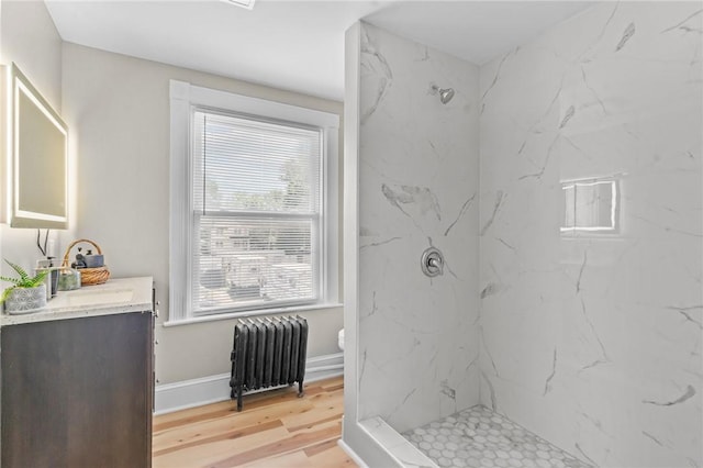 1413 Broad St, Providence, RI 02905 - bathroom with radiator, vanity, a marble finish shower, and wood finished floors