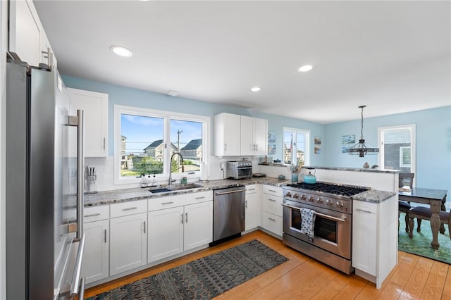 408 Atlantic Ave, Westerly, RI 02891 - kitchen with appliances with stainless steel finishes, a peninsula, white cabinetry, tasteful backsplash, and recessed lighting
