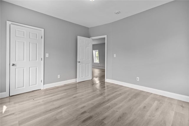 406 Cahill St, Providence, RI 02905 - unfurnished bedroom with wood finished floors and baseboard heating
