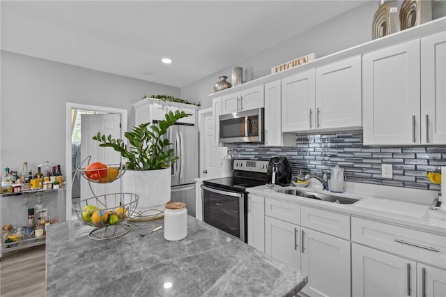 406 Cahill St, Providence, RI 02905 - kitchen featuring stainless steel appliances, white cabinets, tasteful backsplash, light wood-type flooring, and recessed lighting